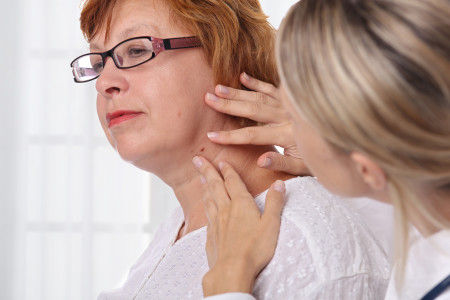 Dermatologist examines birthmark of senior woman
