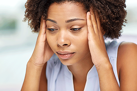 Woman touching her temples to soothe pain caused by CCCA